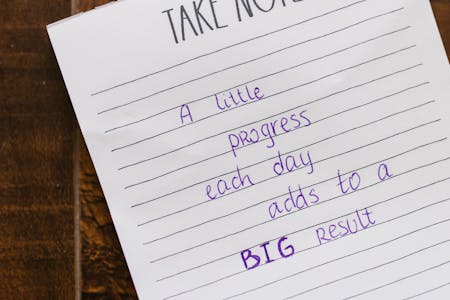 Motivational note on paper with handwritten text on a wooden table.